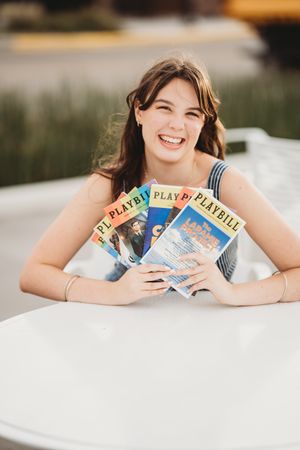 A collection of vintage Playboy magazines arranged in a row on a light colored surface during an outdoor photo session.