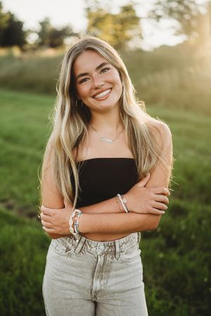 A series of outdoor portrait photos showing someone in a black top and light denim against a sunlit natural background.