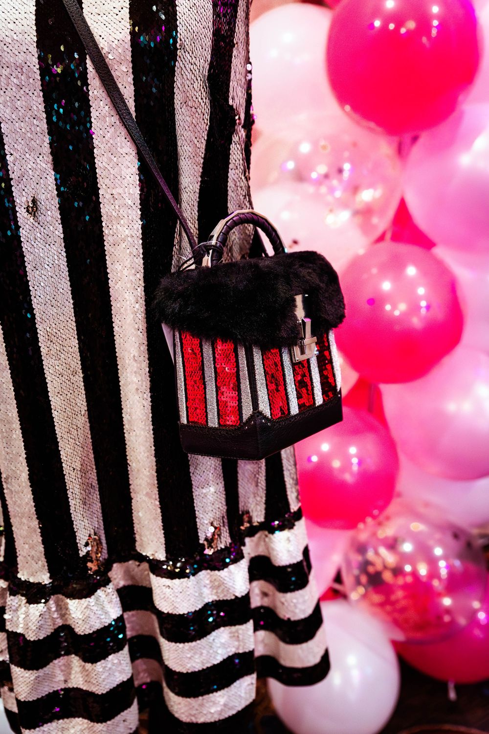 Black and white striped backdrop with a decorative lantern and pink party balloons creating a festive atmosphere.