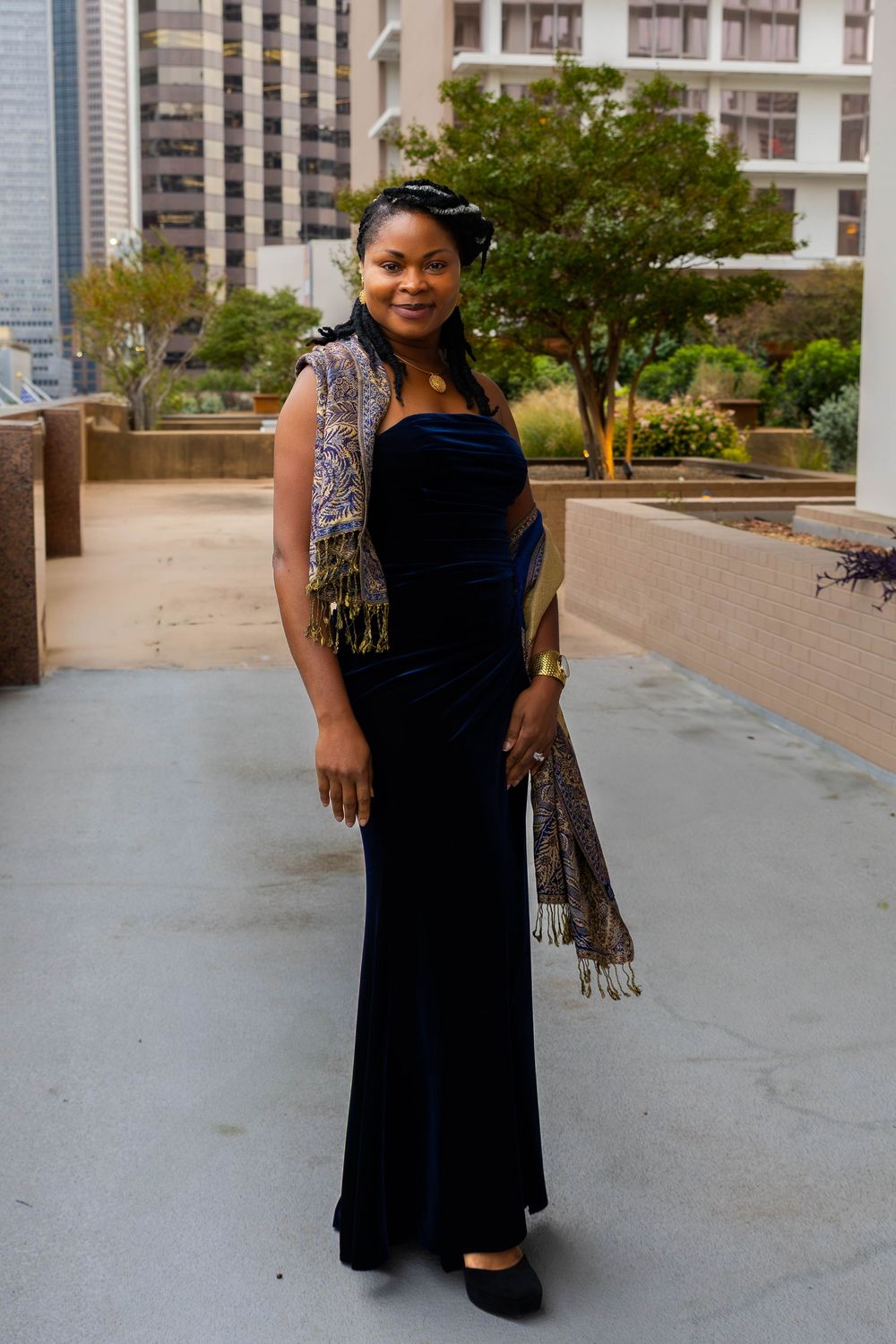 Elegant formal portrait on rooftop terrace featuring navy velvet gown and decorative scarf.