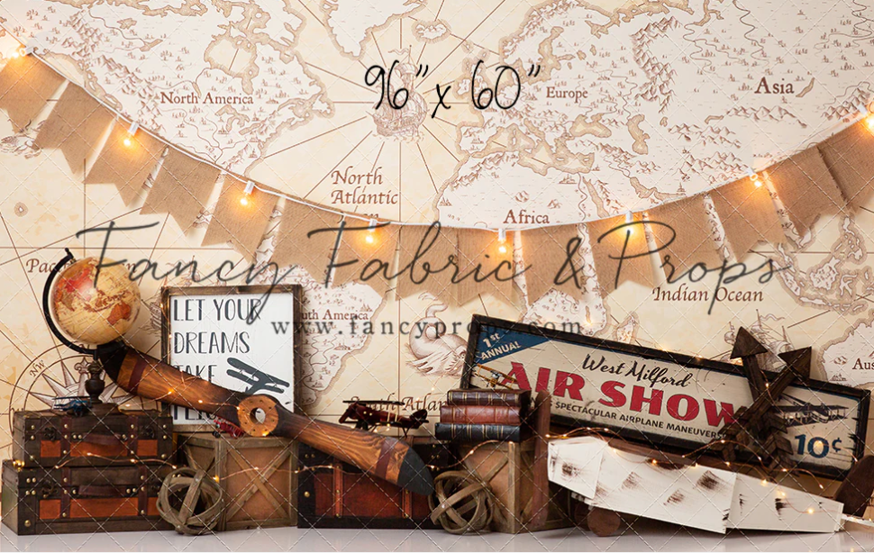 A collection of vintage maps, fabric samples, and antique props arranged in a horizontal collage layout.
