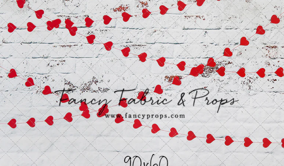 Red heart garland decorates a white textured background with rustic farmhouse style.