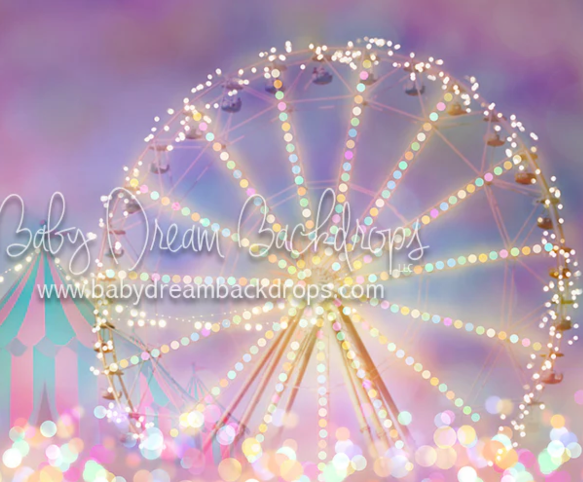Illuminated Ferris wheel glowing with warm lights against a dreamy purple and pink sky at dusk.