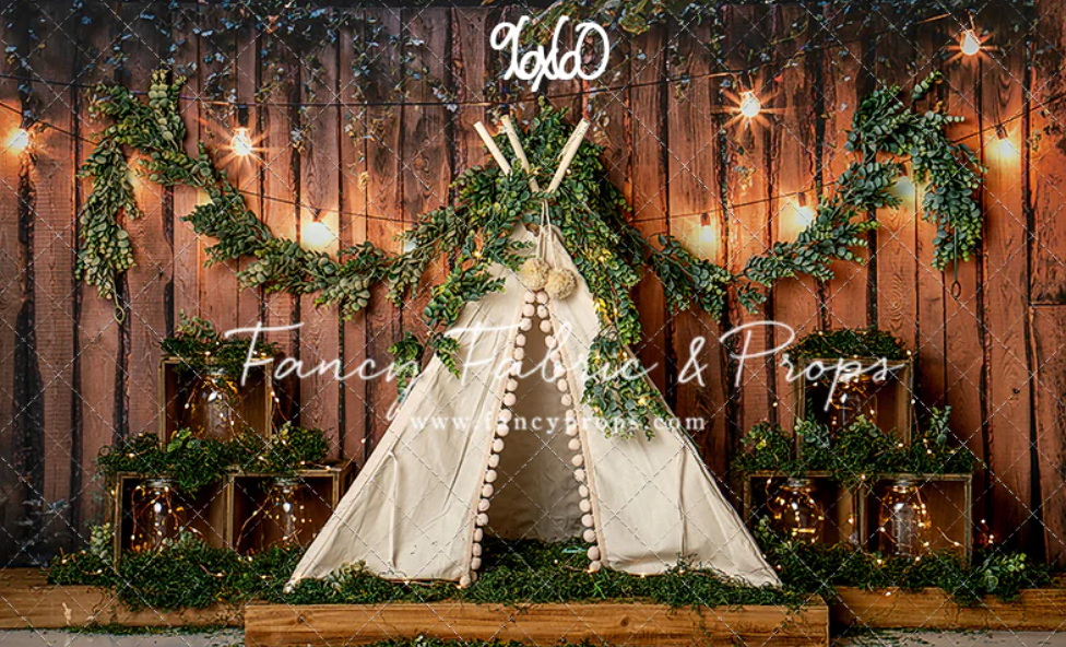 Rustic wooden fence decorated with string lights and evergreen garland creates a warm holiday backdrop.