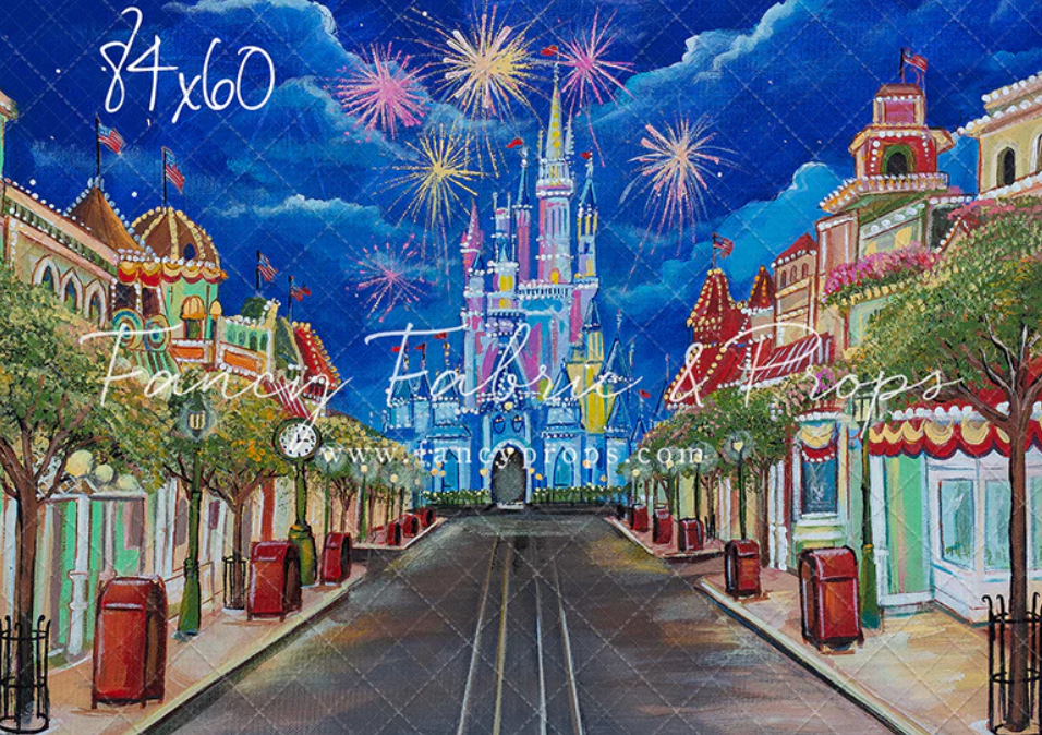 Panoramic view of Main Street USA at Disney World with fireworks bursting in the dark blue sky above colorful buildings.