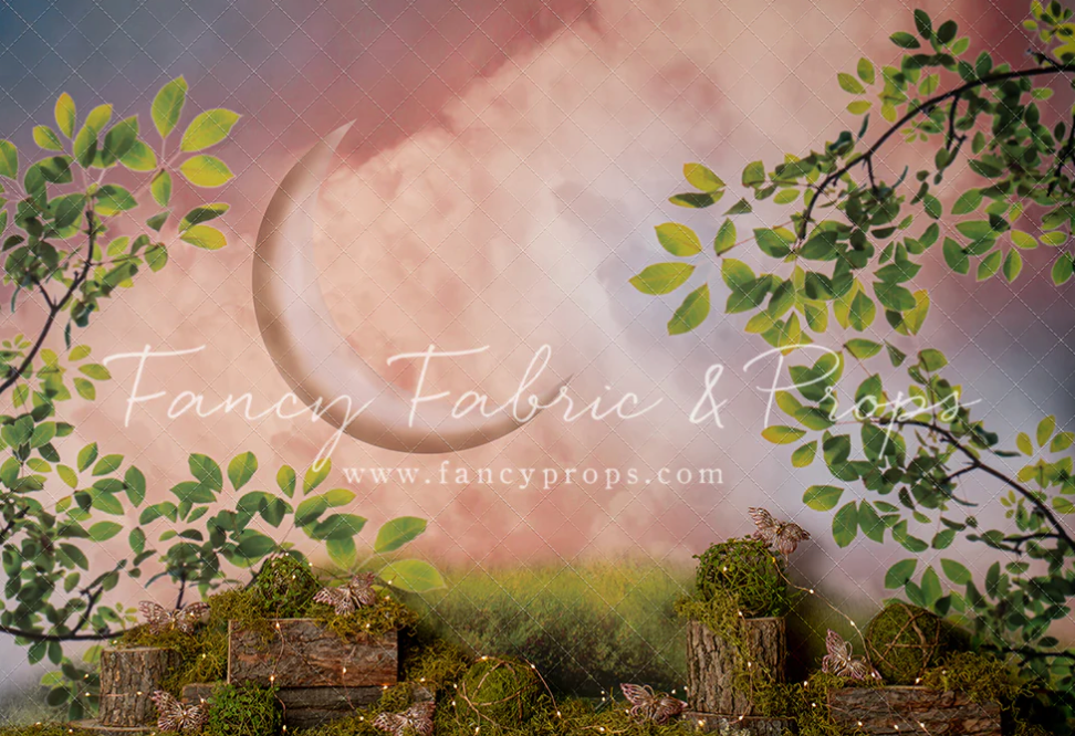 Scenic panoramic view of a sunset sky with green tree branches framing the top of the image.