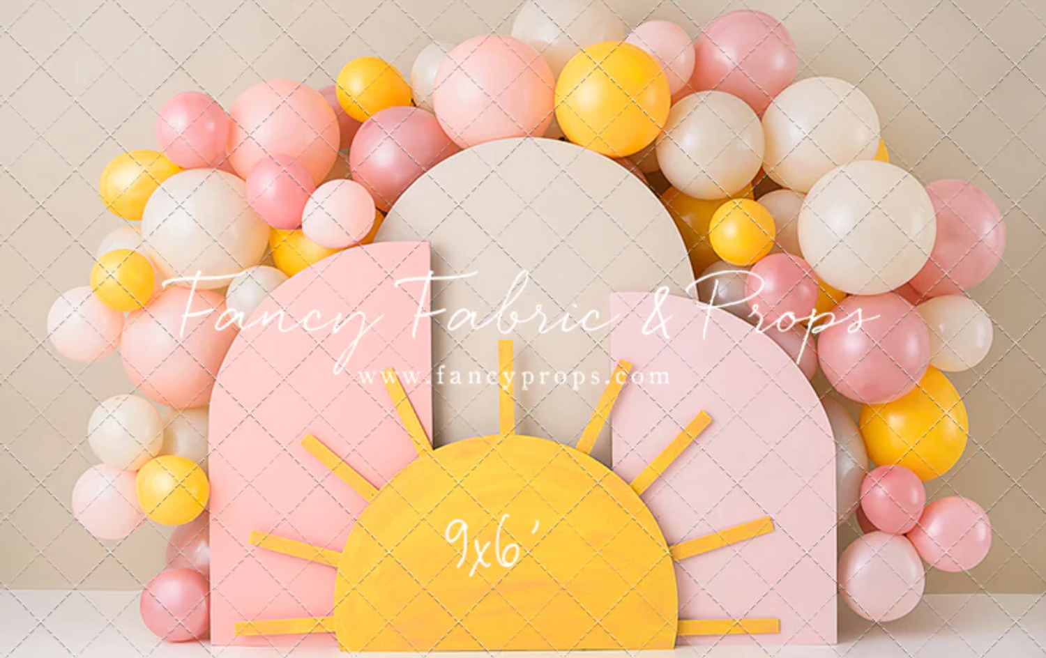 Pastel pink and yellow balloon arch with a sunrise-shaped centerpiece creates a whimsical party backdrop.