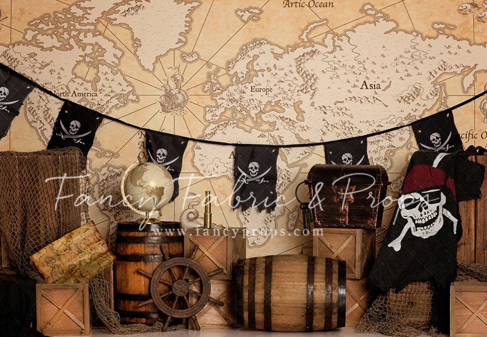 Vintage pirate themed decoration with skull flags, wooden barrels, and antique world map backdrop.