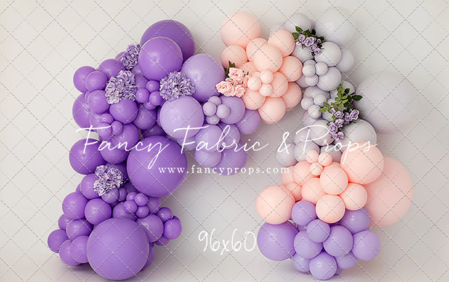 Purple and peach balloon garland with floral accents creates an elegant party decoration display.