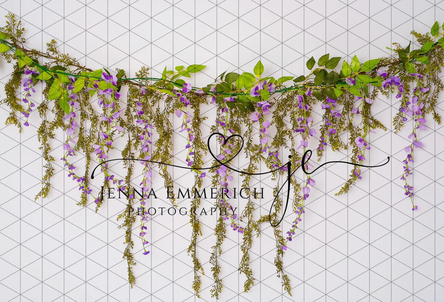 Decorative floral garland with hanging wisteria and greenery against geometric patterned wall.