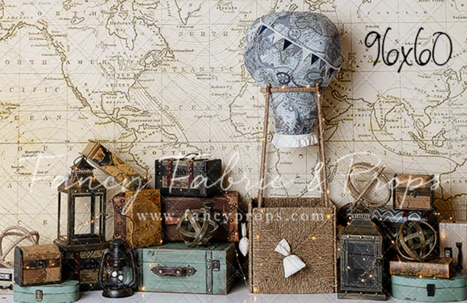 Vintage cameras, suitcases, and antique items arranged in a rustic display against a map background.