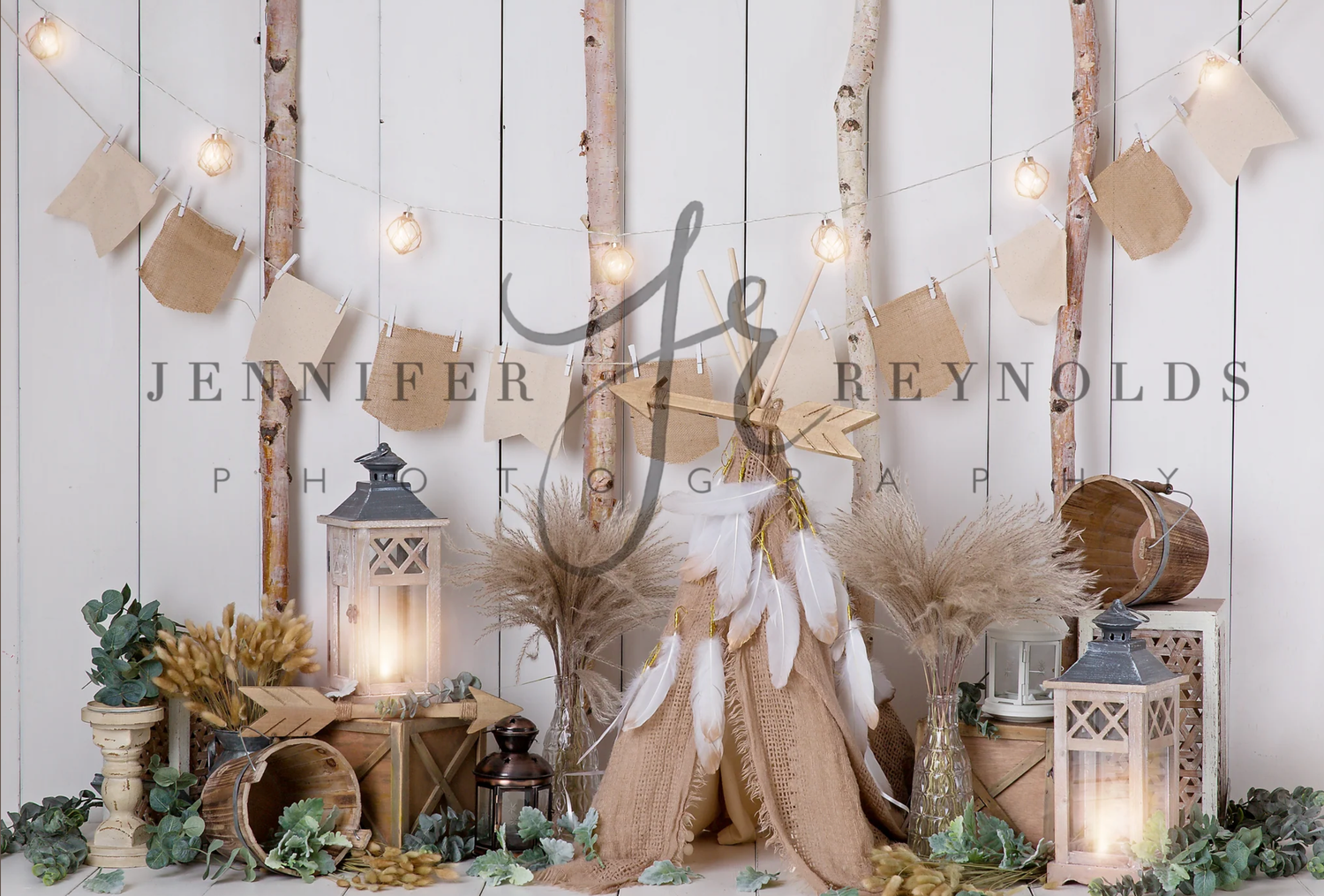 White wooden wall decorated with natural holiday ornaments, lanterns, and neutral-toned Christmas decor creates a cozy display.