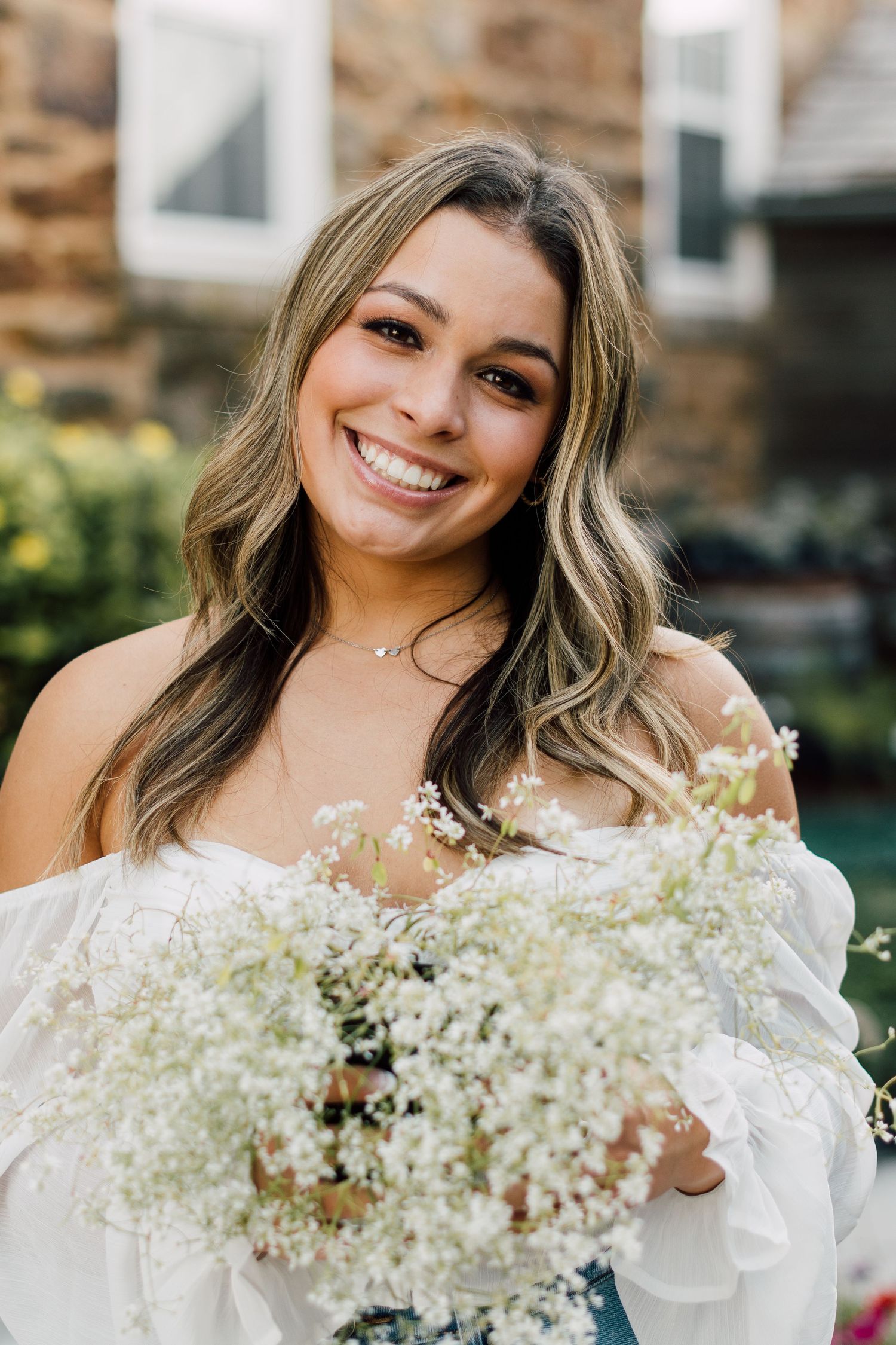 Portrait with white baby's breath flowers in delicate white dress.