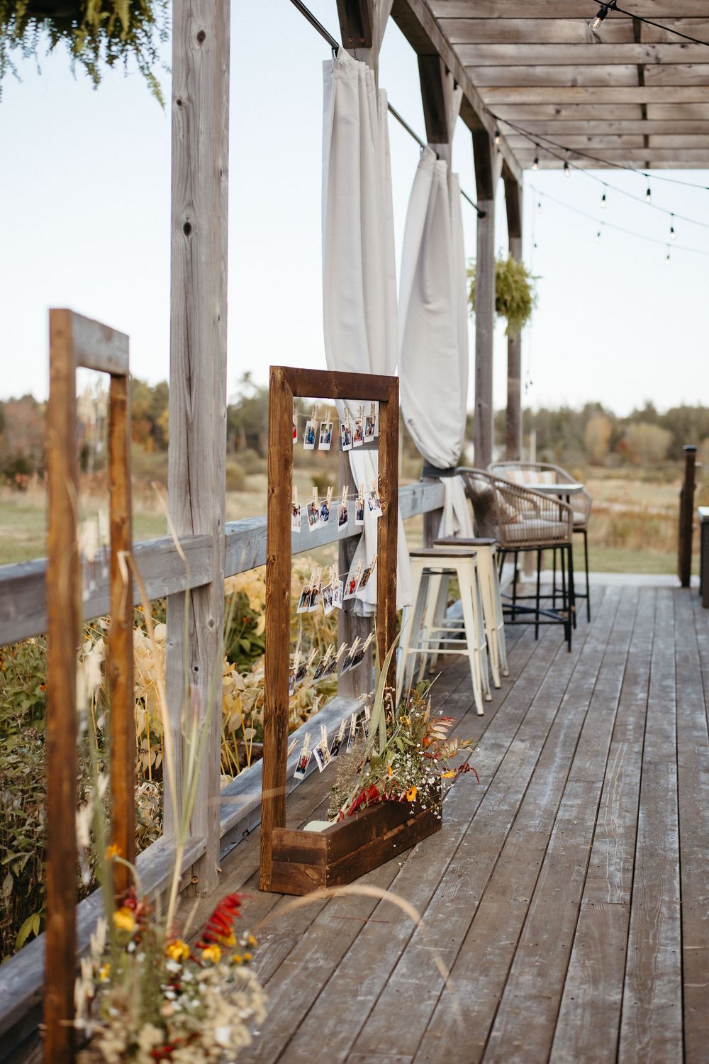 simple photo wall wedding decor outside covered patio at Ticklebelly Hill, rustic wedding venue photography in New Brunswick Canada