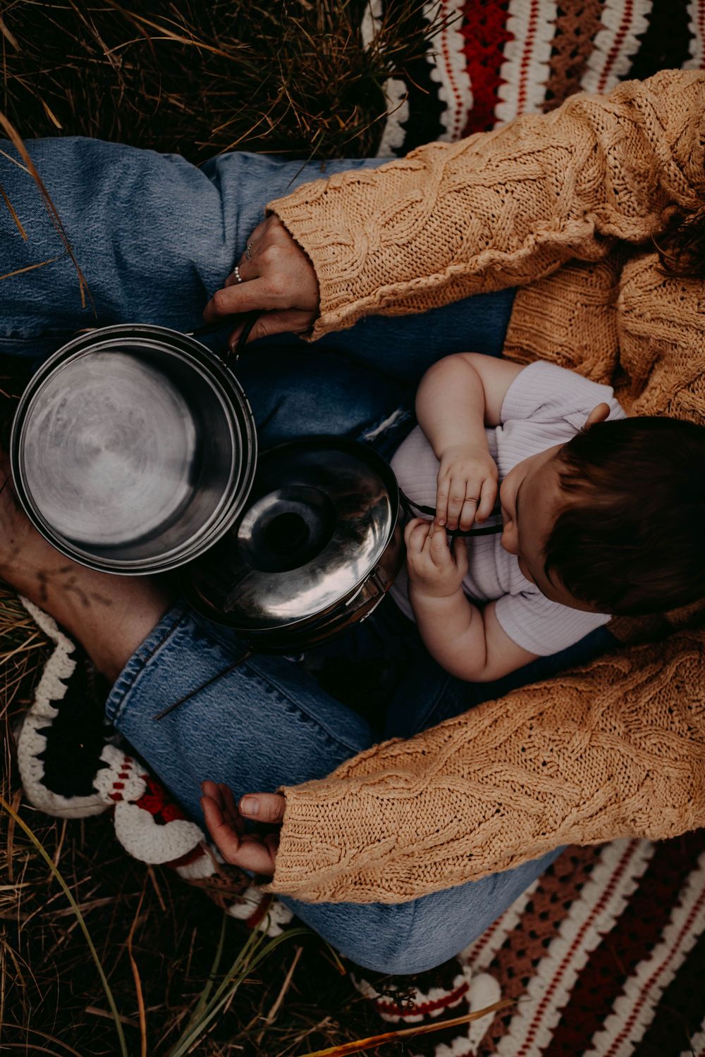 Close-up details of hands and blankets during an intimate outdoor picnic setting.