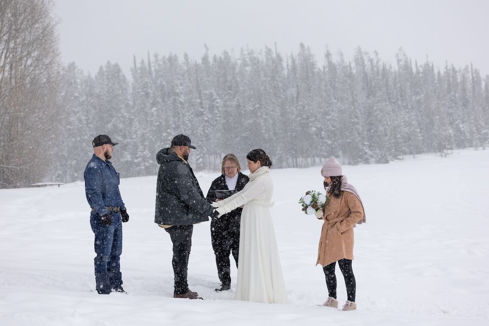People gather in a snowy winter landscape taking photos during what appears to be an outdoor photo session.