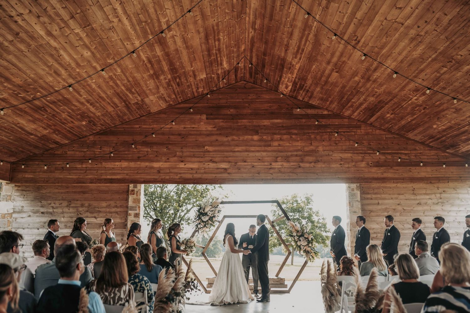 Emotional wedding ceremony moment with guests smiling and watching couple exchange vows