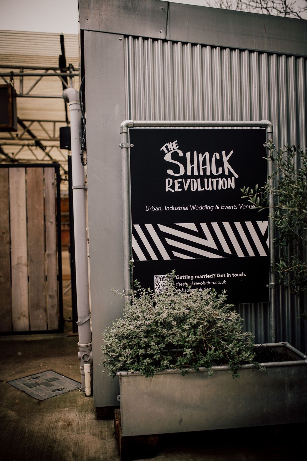 Black and white storefront signs for Revolution and Shack establishments with modern industrial styling.