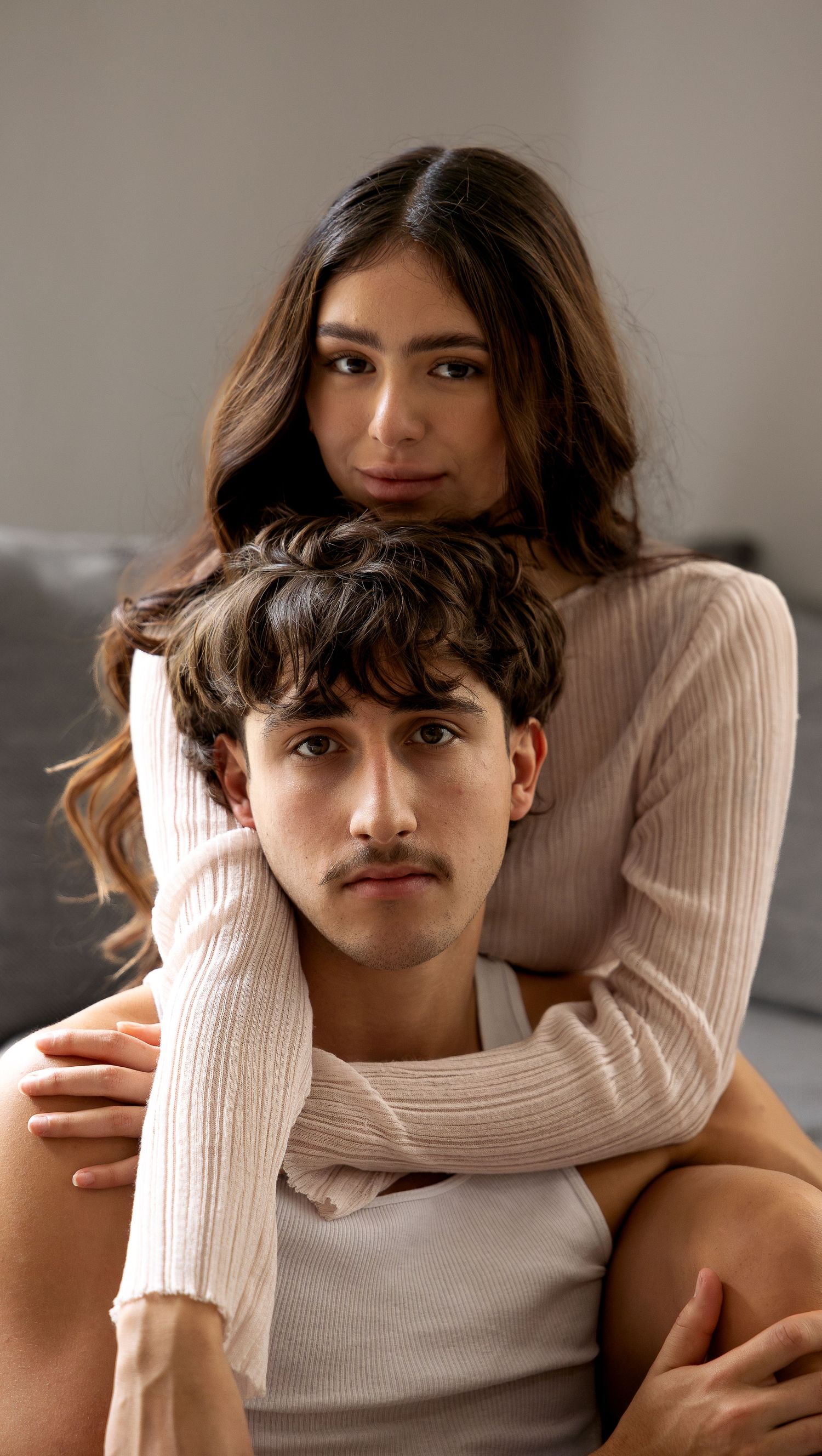 A series of portrait shots showing someone in a cream sweater posing against a neutral background.