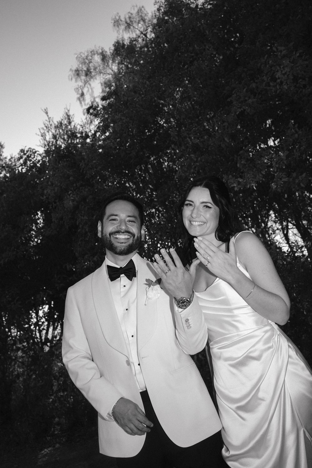 Black and white photo series showing joyful wedding party members in formal attire dancing and celebrating outdoors.