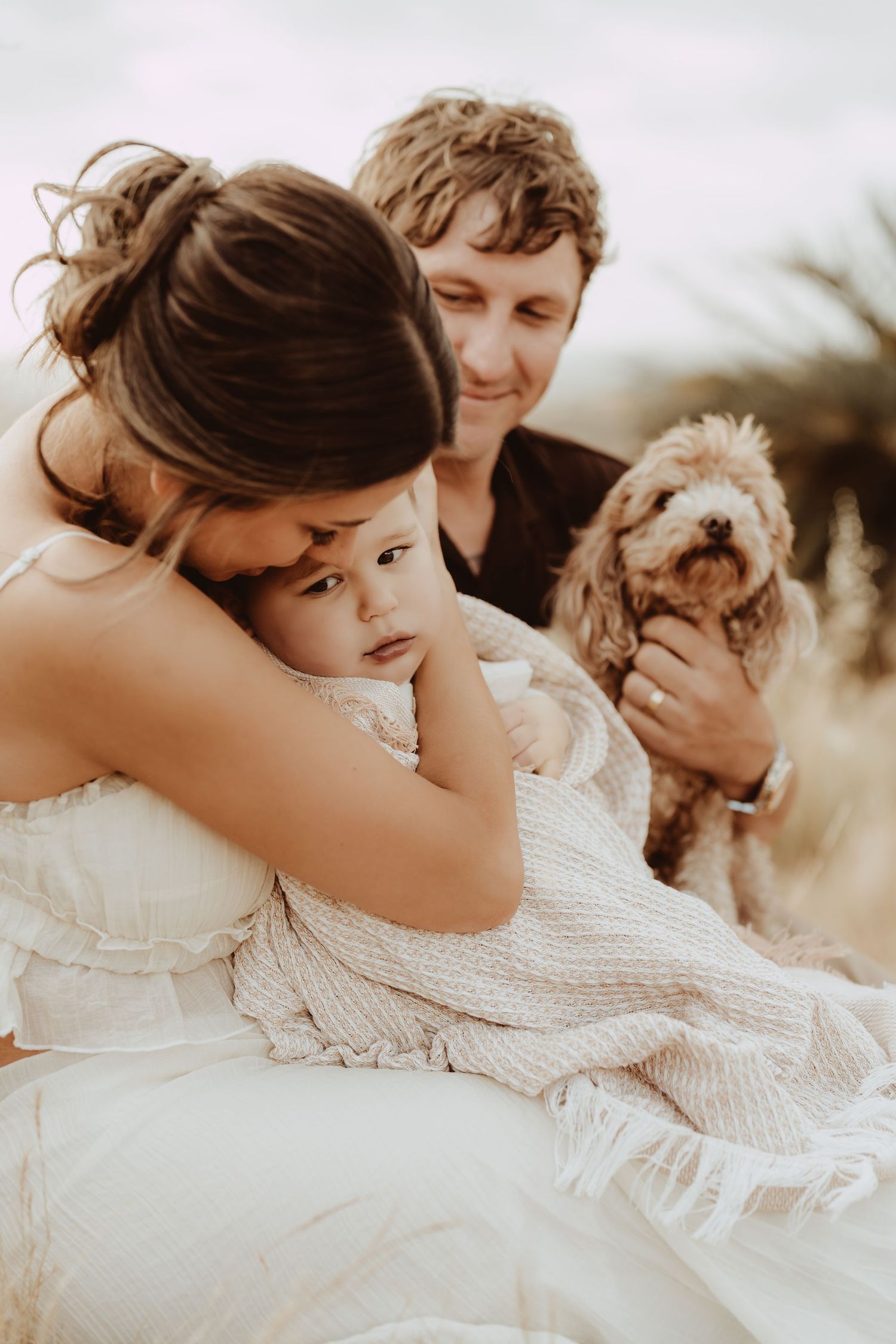 Romantic couple in white clothing embrace and share intimate moments in a series of sepia-toned photographs.