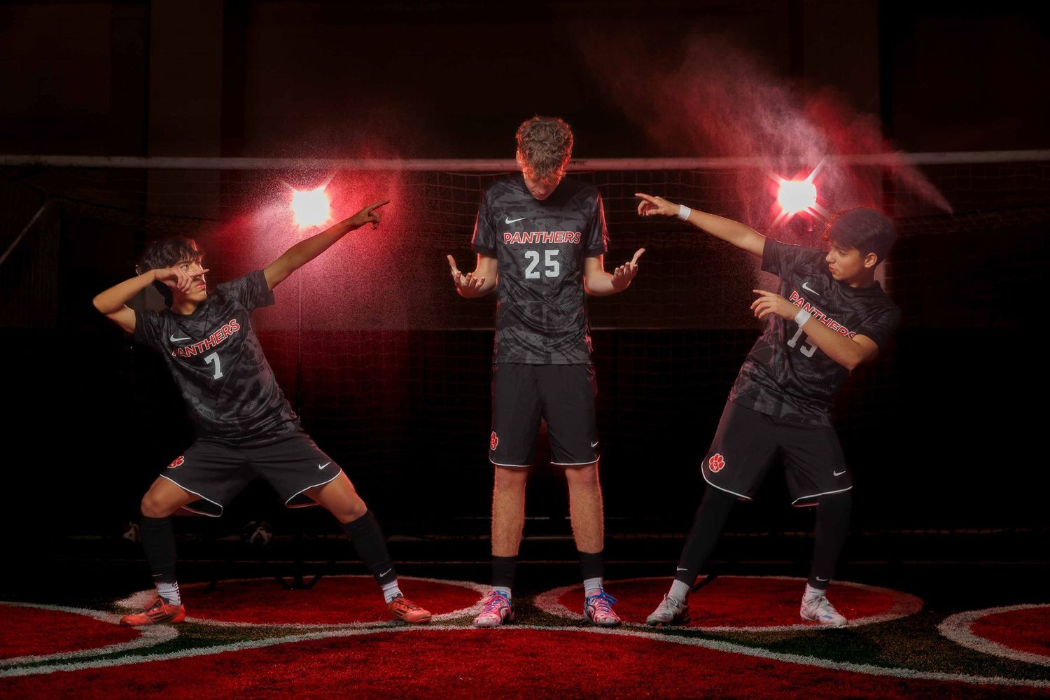 Basketball player wearing red and black uniform dribbles ball on court during intense game action.