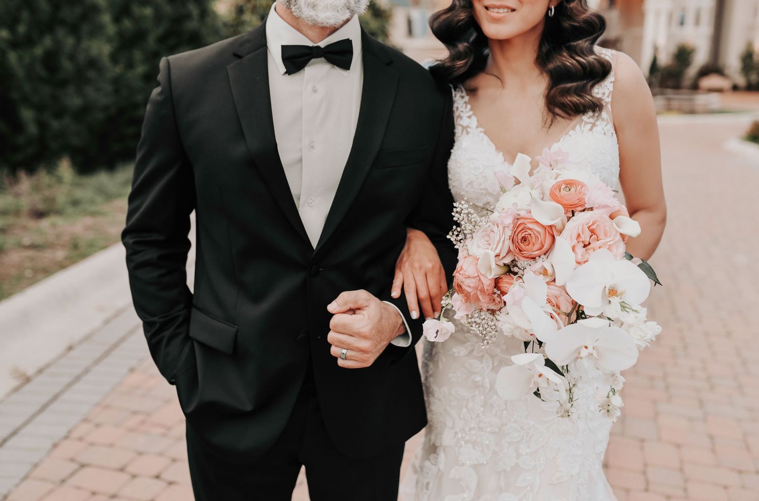 Bride resting her head on groom’s chest during vineyard wedding portraits