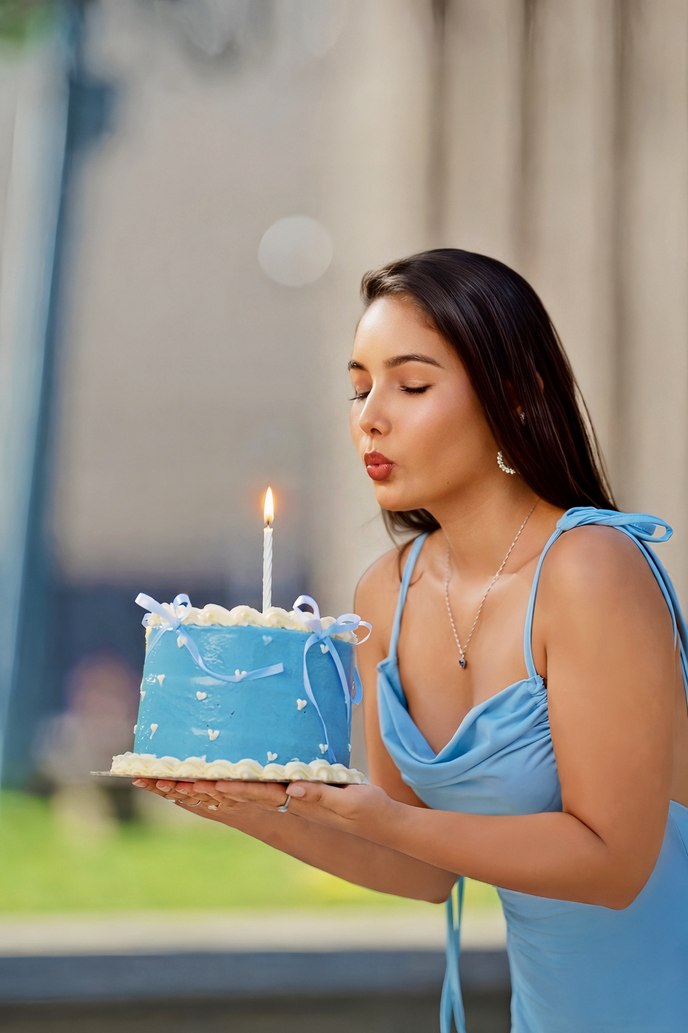 Woman in light blue dress blows out birthday candle on cake in sequence of four connected photos.