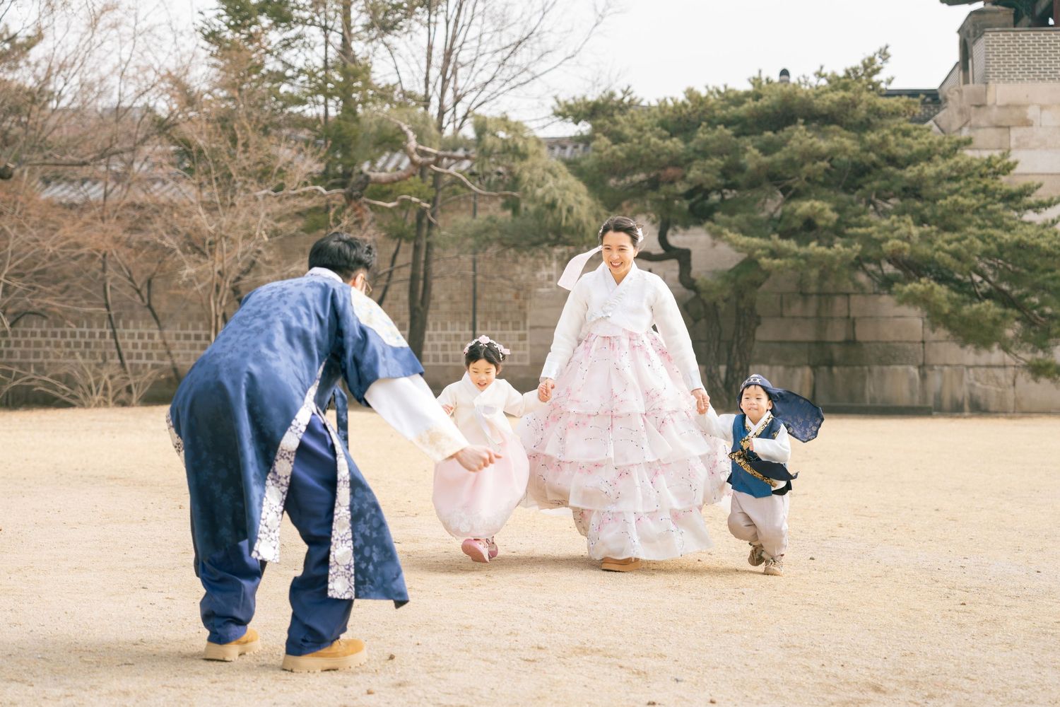 A playful scene in a park with people in traditional Korean hanbok dress enjoying a fun outdoor moment together.
