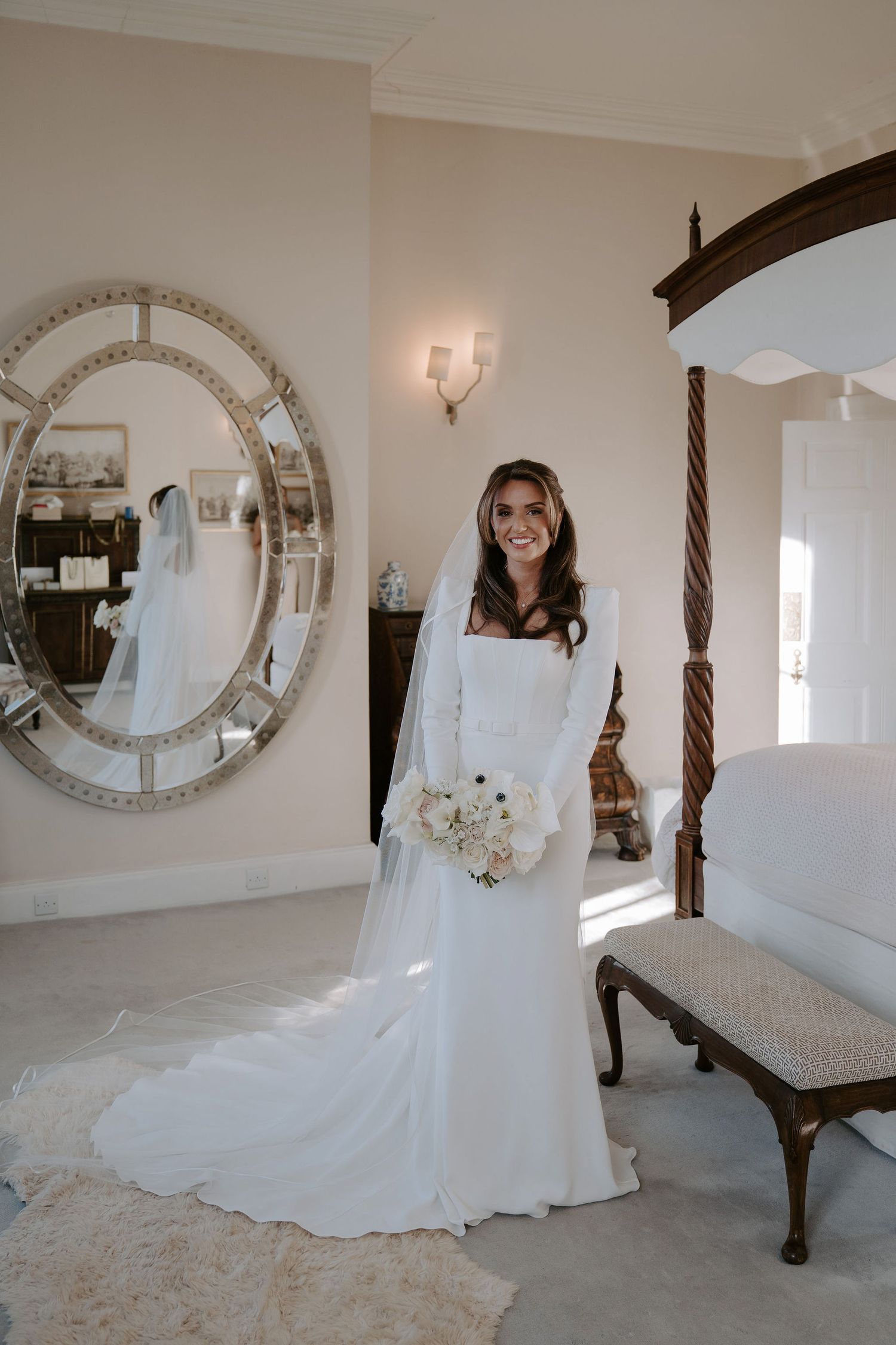 bride stood in her wedding dress holding her bouquet in the bridal room at Iscoyd park