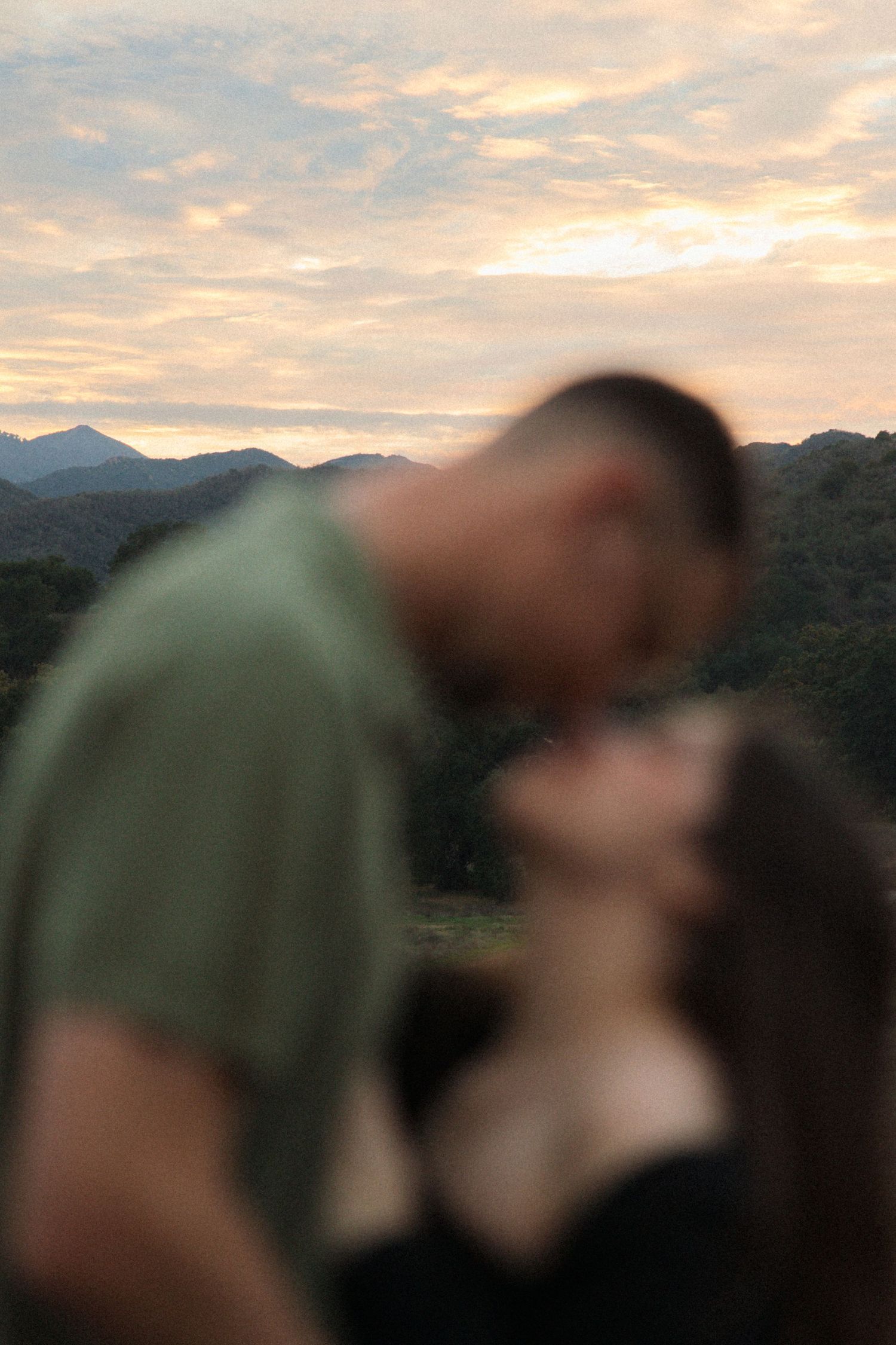 Artistic engagement session in Agoura Hills at sunset with the couple out of focus and glowing sky