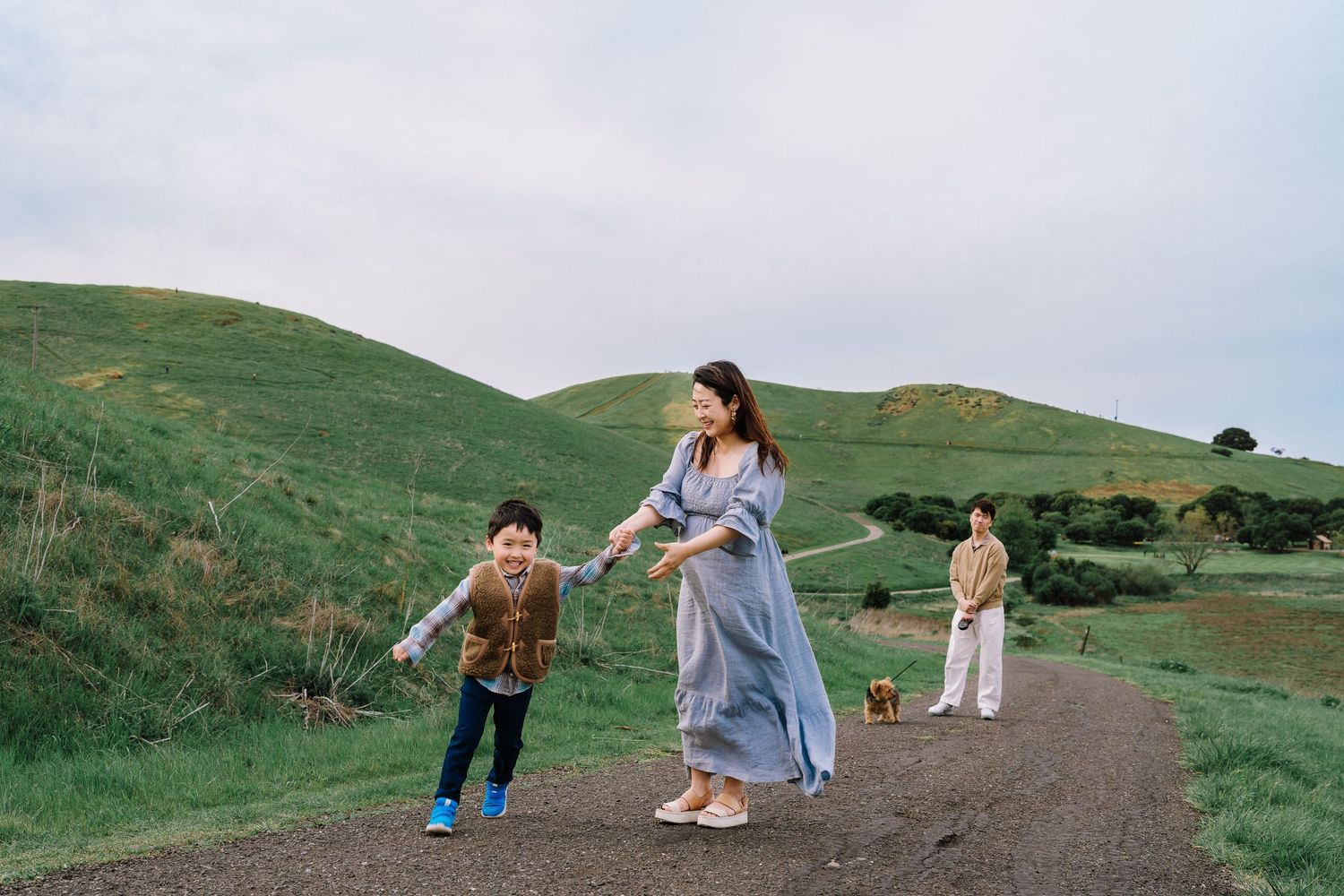 A sequence of candid moments showing people enjoying a scenic hillside landscape on a cloudy day.