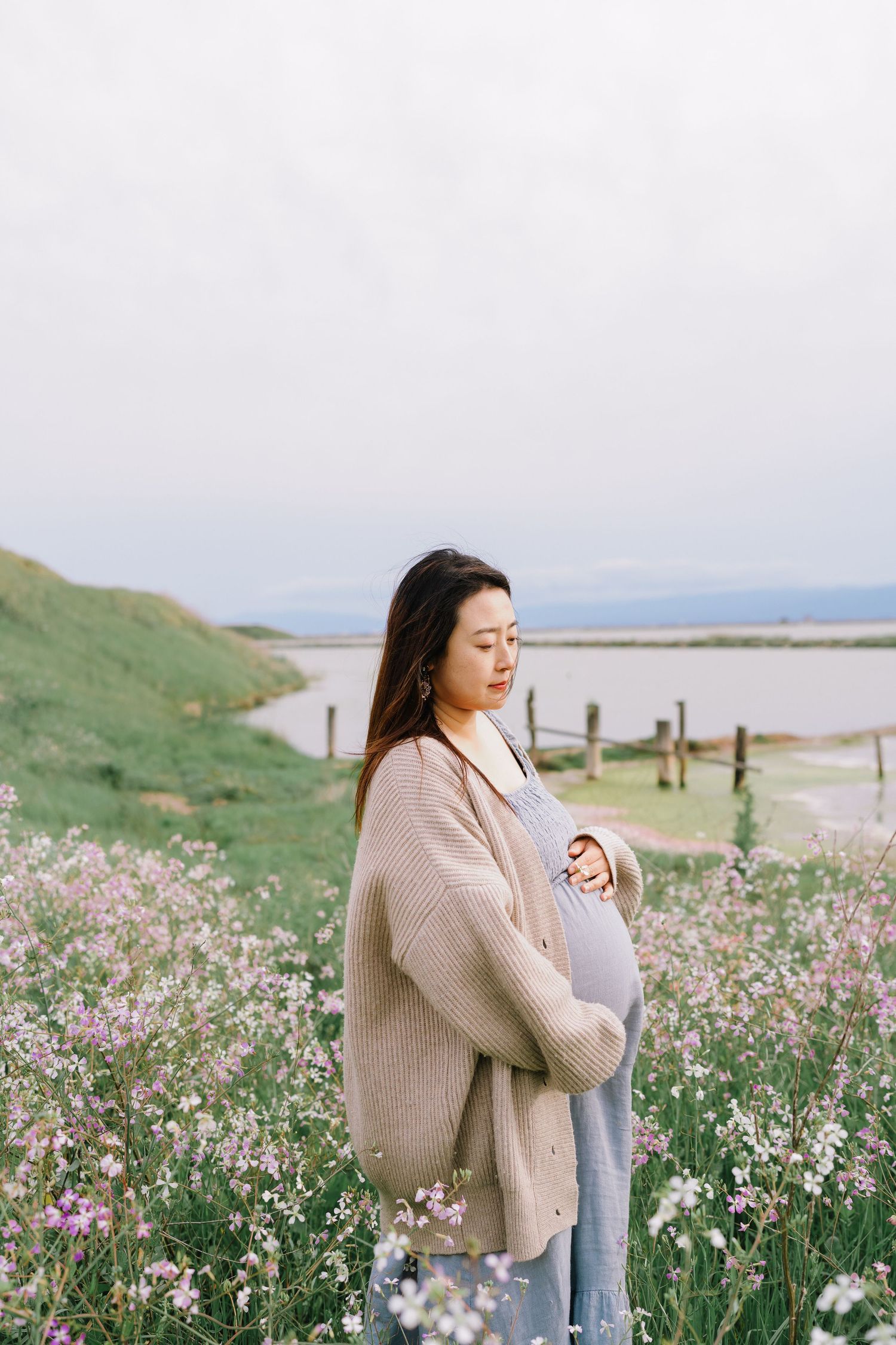 A dreamy coastal scene with wildflowers in bloom along a seaside path as someone enjoys the peaceful landscape.