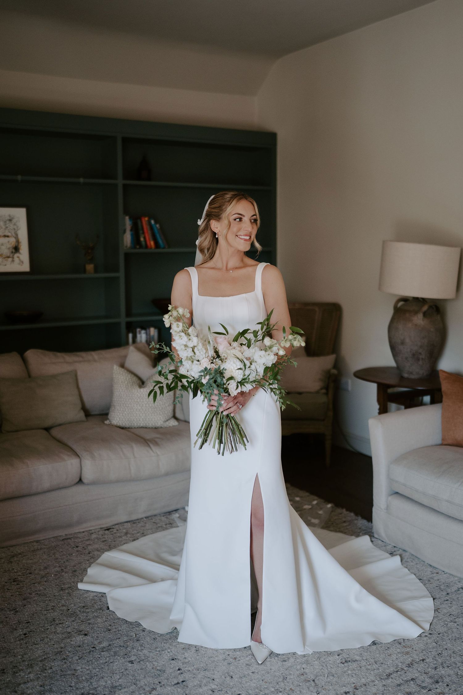 bride smiling holding bouquet at ivy lodge in cirencester