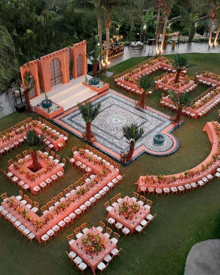 Aerial view of Moroccan-inspired outdoor wedding with coral table arrangements and mosaic floor.
