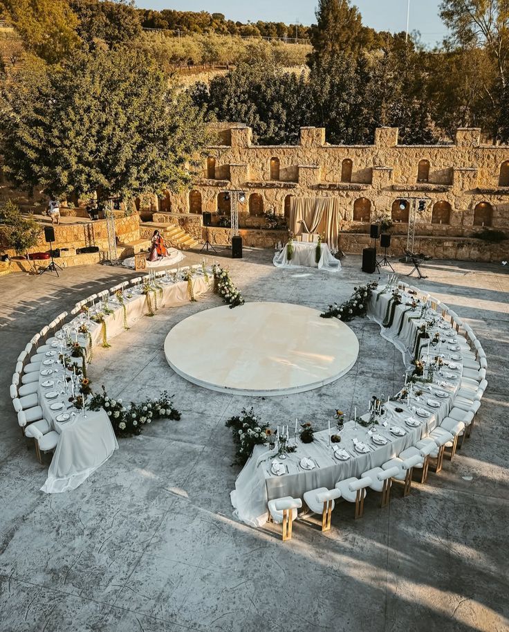 Aerial view of circular wedding reception layout with long tables around a dance floor.