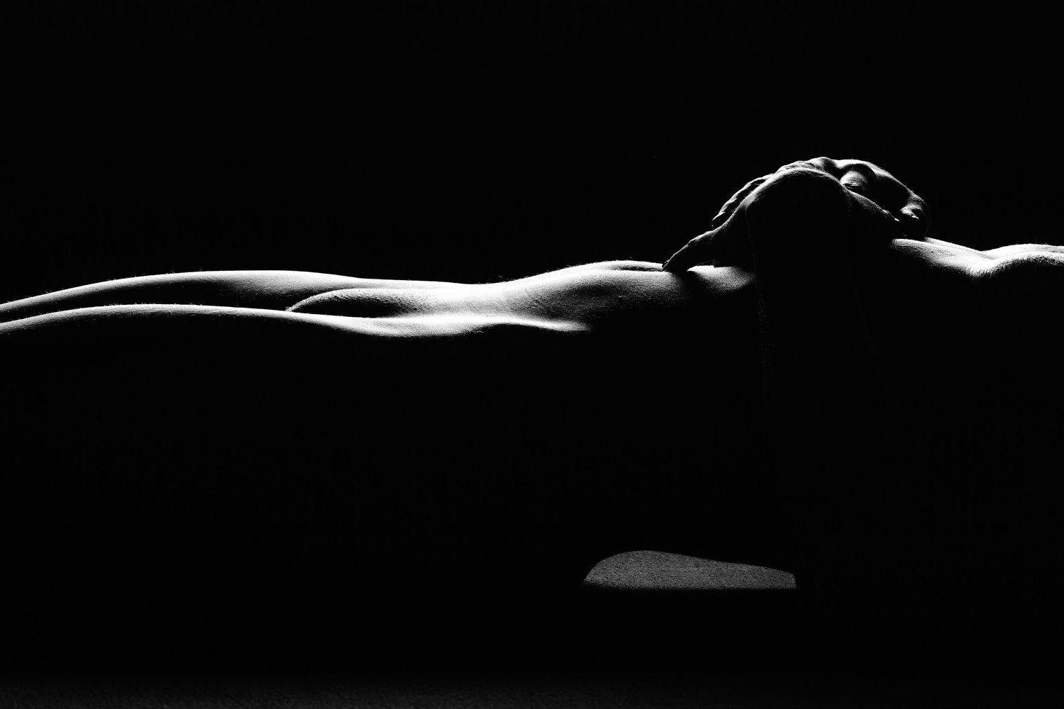 David G Holt Photography - Minimalist black and white photograph showing graceful body curves in low light.