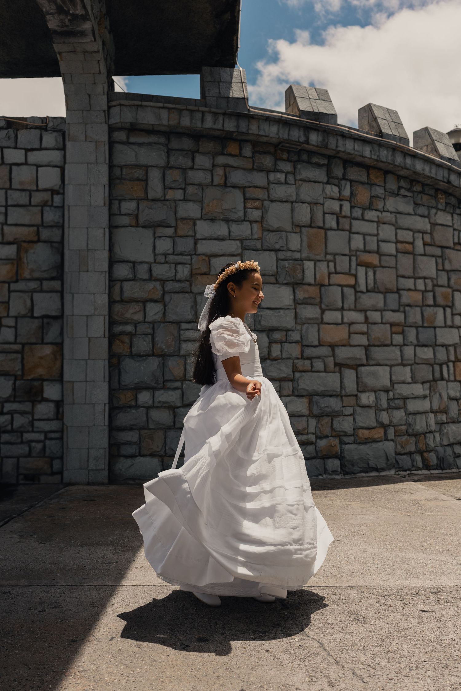 A person in a flowing white wedding dress twirls against a stone castle wall in a series of dynamic motion shots.