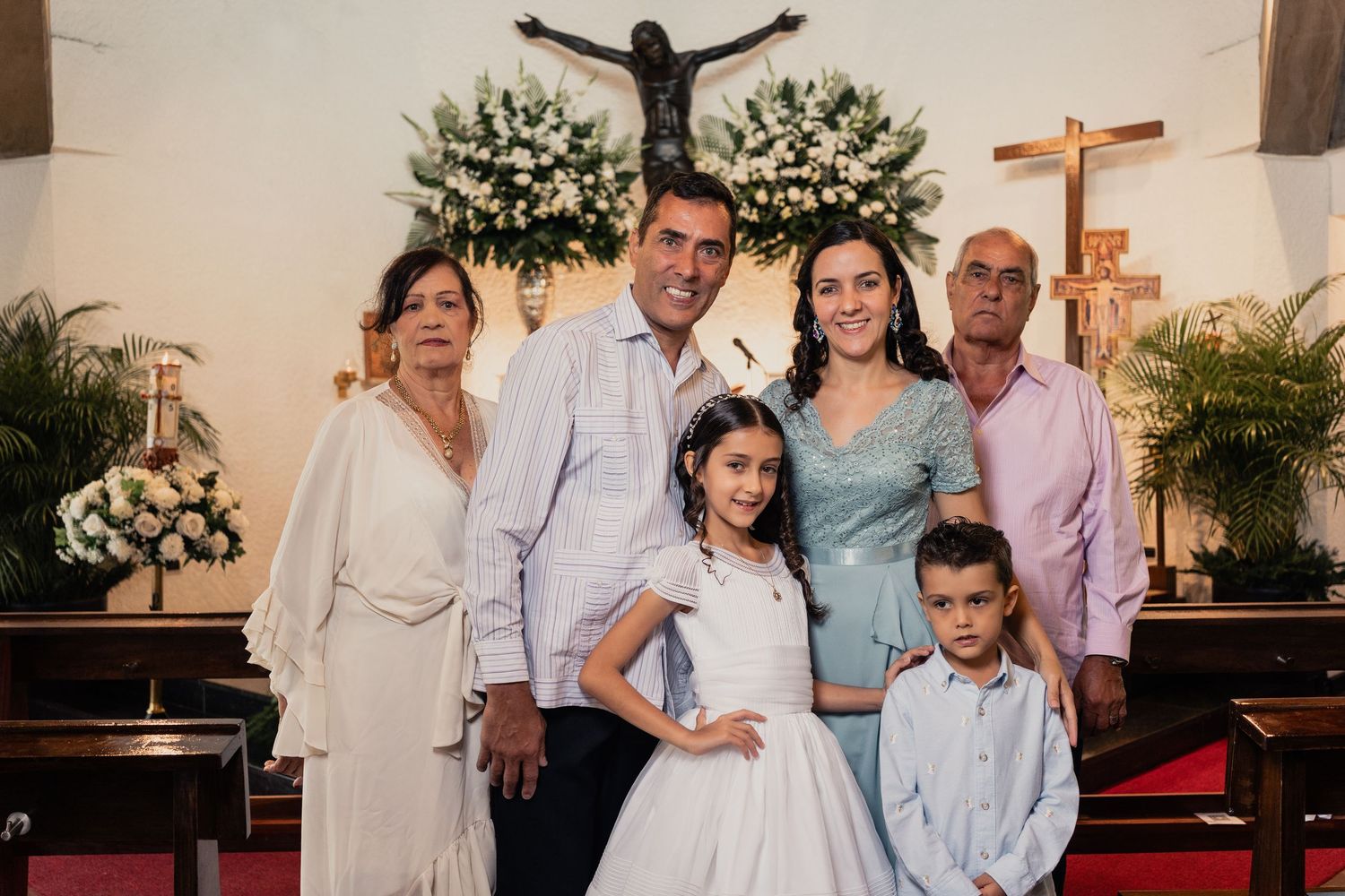 A group poses together at a church event wearing coordinated pastel blue and white outfits.