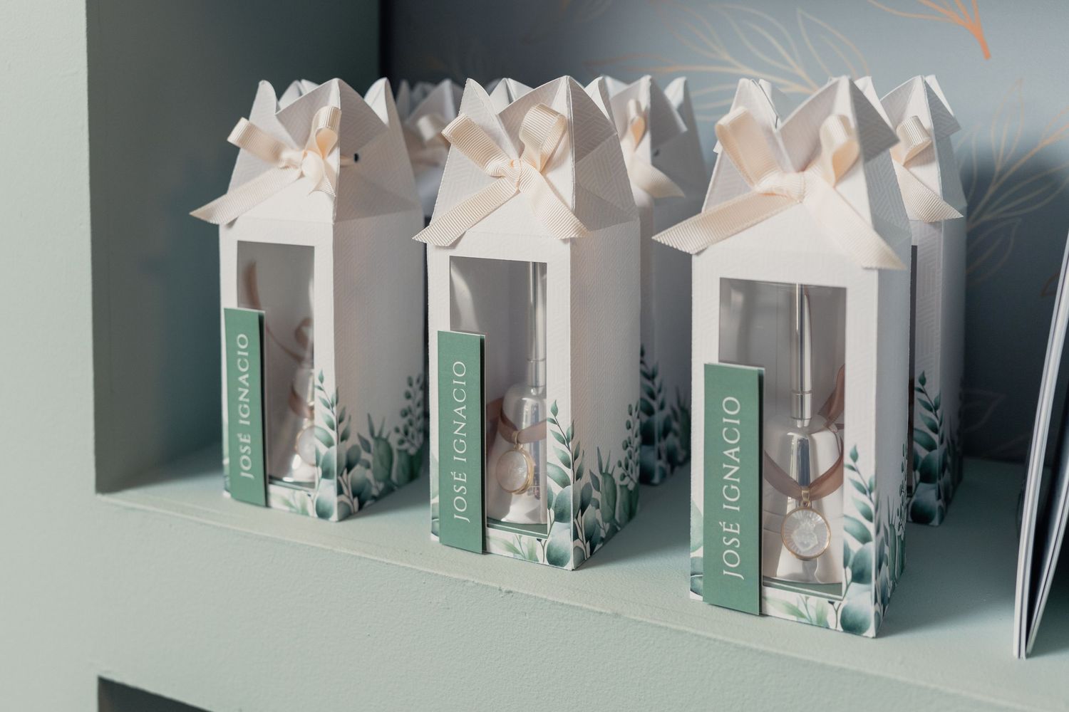 White decorative retail product boxes with floral designs displayed on gray shelf.