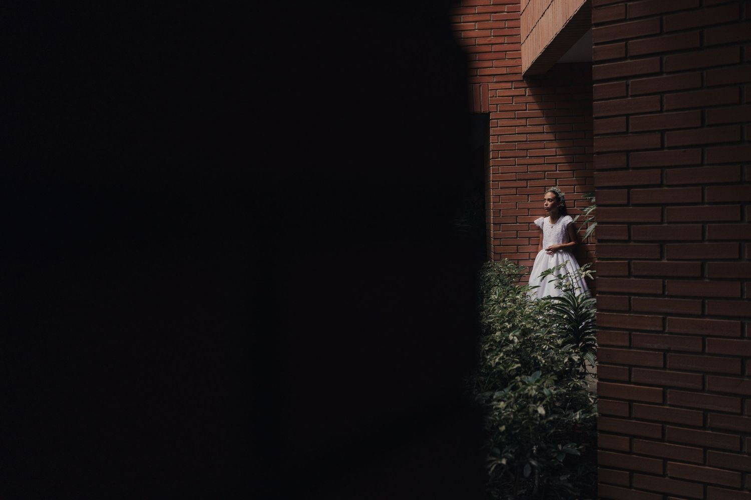 A sequence of eight dark doorways or openings in a brick wall creates a repeating architectural pattern.