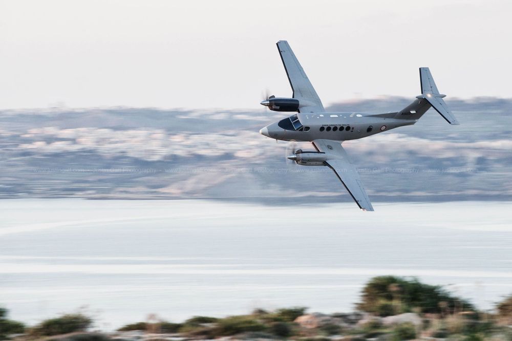 Military transport aircraft flying in formation over water during maritime patrol mission.