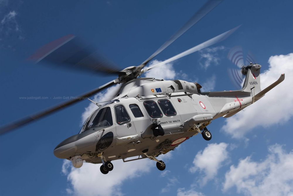 Formation of military helicopters conducting aerial maneuvers over cloudy skies.