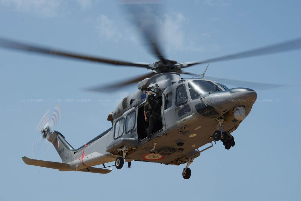Military helicopters in formation flight against clear blue sky background.
