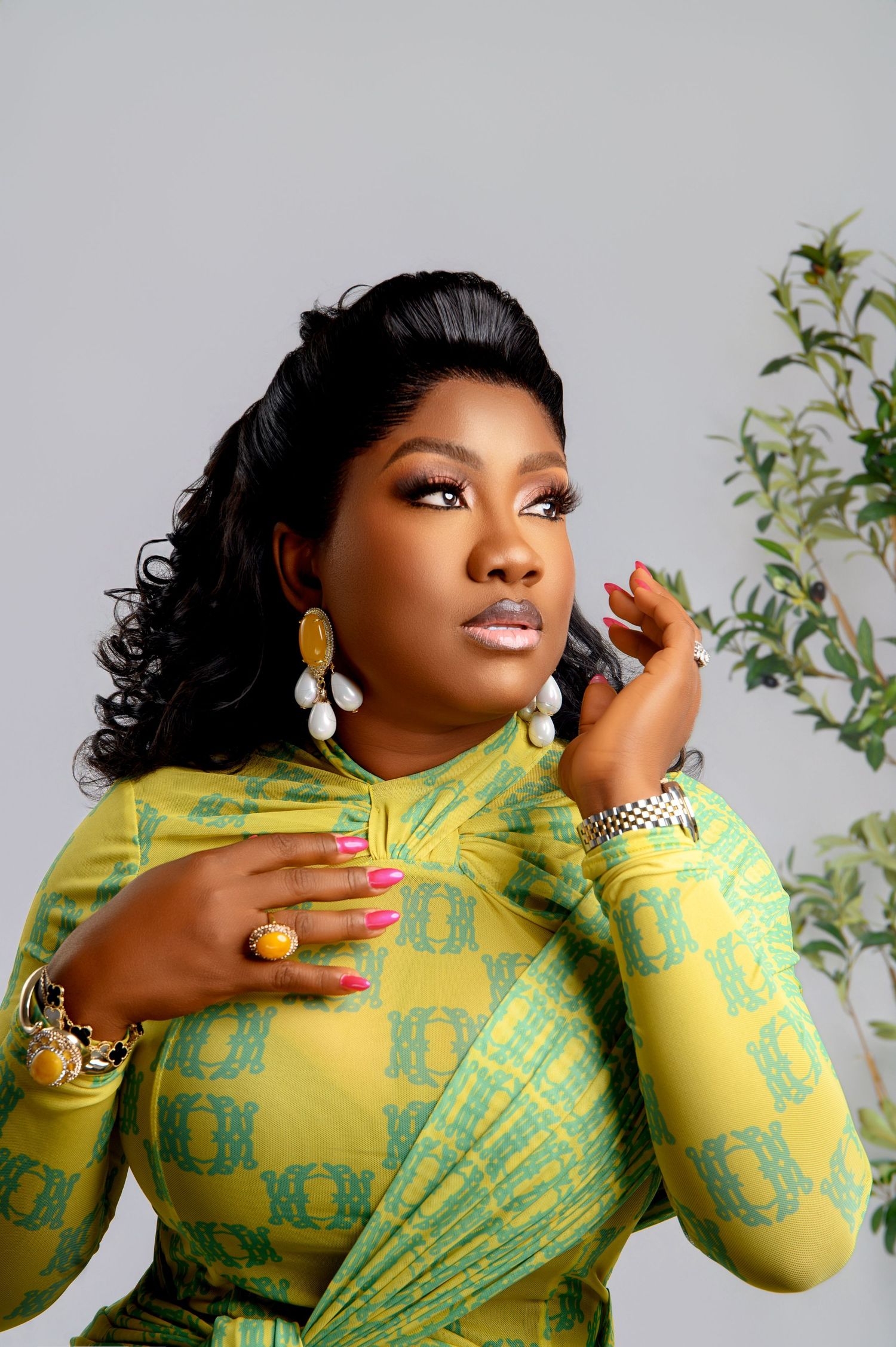 Fashion portrait in yellow and green patterned dress with statement jewelry.