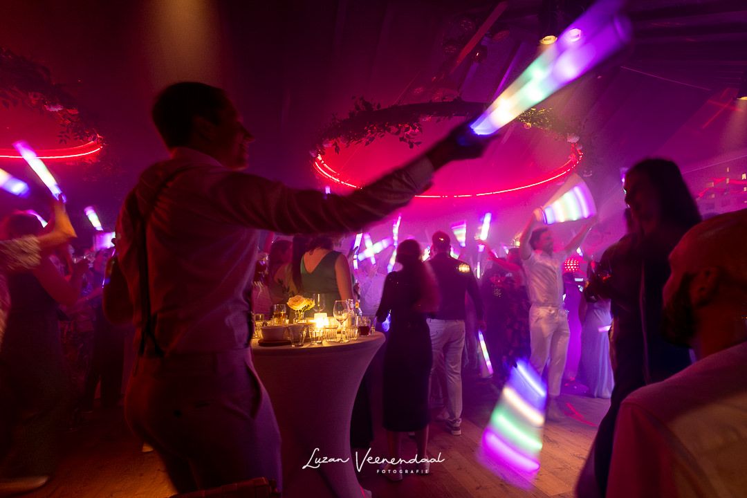 Sfeervolle feestavond met kleurrijke lichtshow en lichtstaven – bruiloft Jesse en Sharon, Zoomers aan het Bos Castricum Noord-Holland