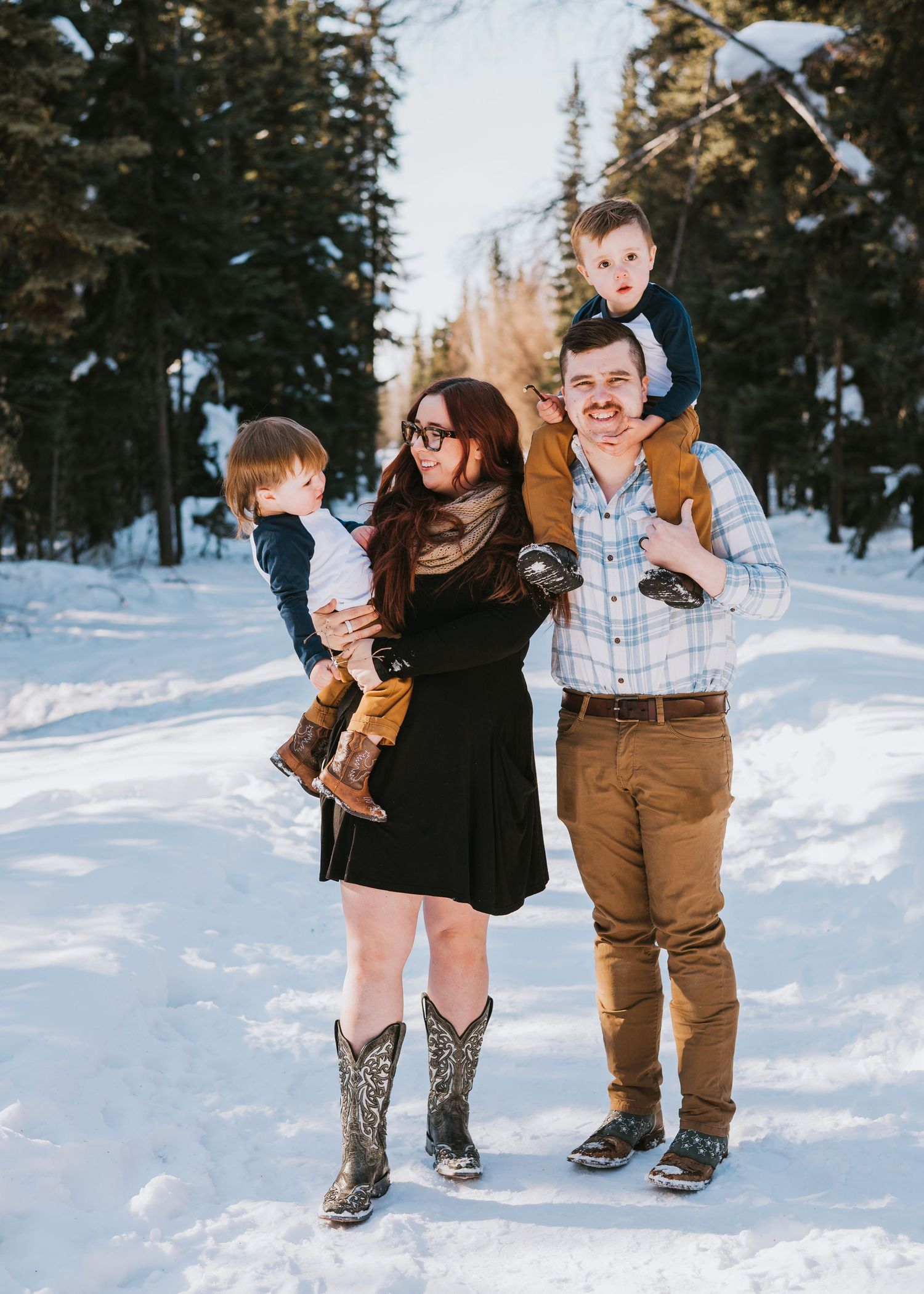 Family standing together outdoors in the snow during a winter family photography session