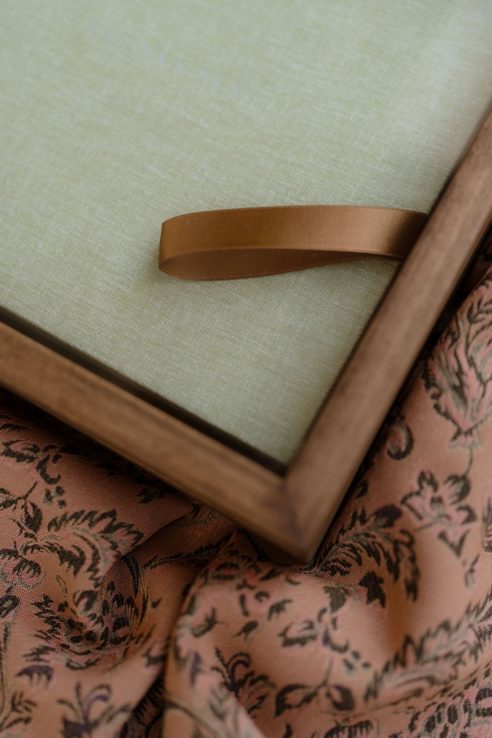 Close-up of brown leather frames against a light linen background with decorative floral patterns.