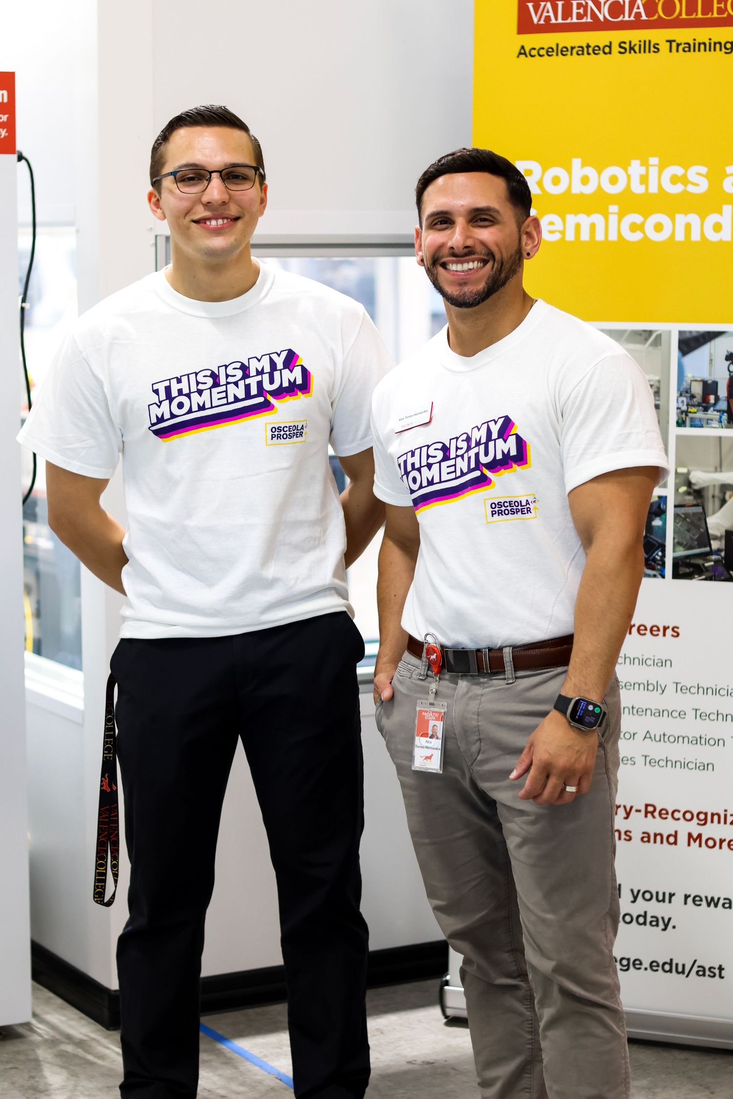 Two men wearing 'This Is My Momentum' shirts smile at a Valencia College Robotics and Semiconductor training event.
