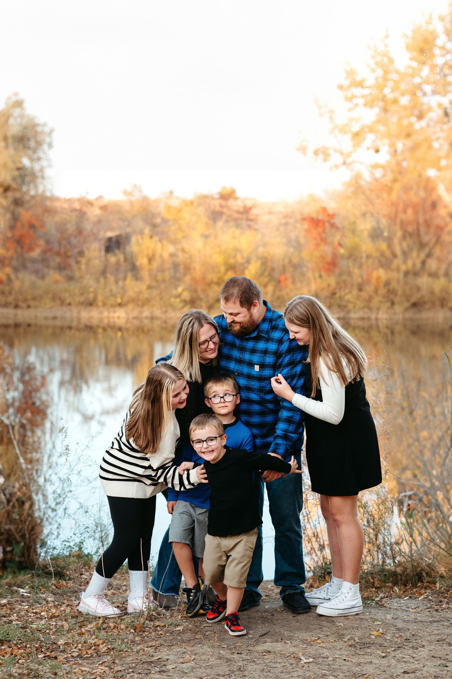 Outdoor family photo near the water with parents and children, warm golden light and timeless Brookings SD family photography edits.